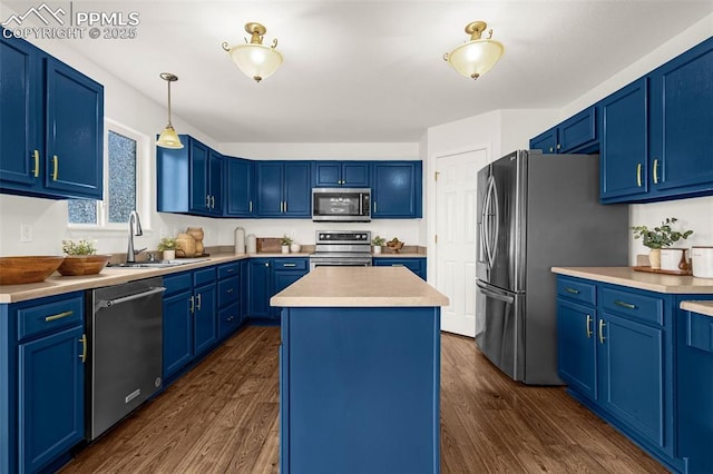 kitchen featuring a kitchen island, blue cabinets, appliances with stainless steel finishes, a sink, and dark wood-style floors
