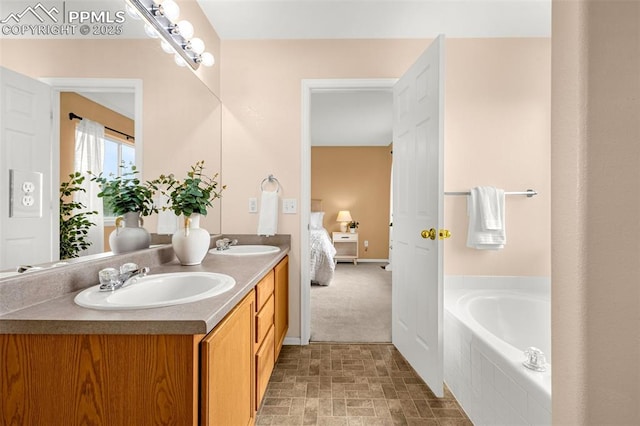ensuite bathroom featuring a bath, double vanity, a sink, and ensuite bathroom