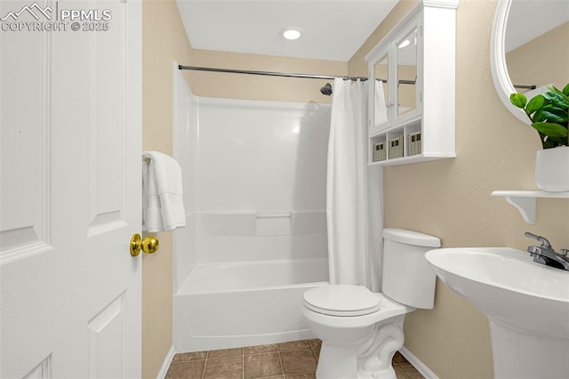 bathroom featuring shower / bath combo, a sink, tile patterned floors, baseboards, and toilet