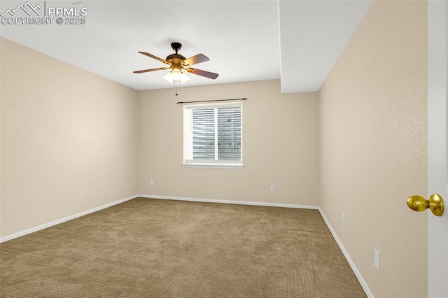 carpeted spare room featuring a ceiling fan and baseboards