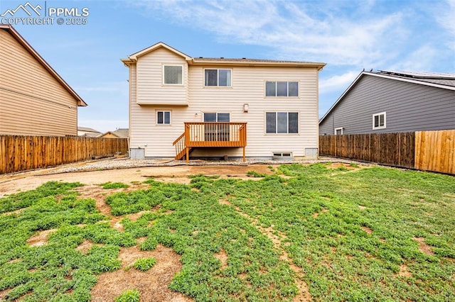 back of house with a fenced backyard, a yard, and a deck