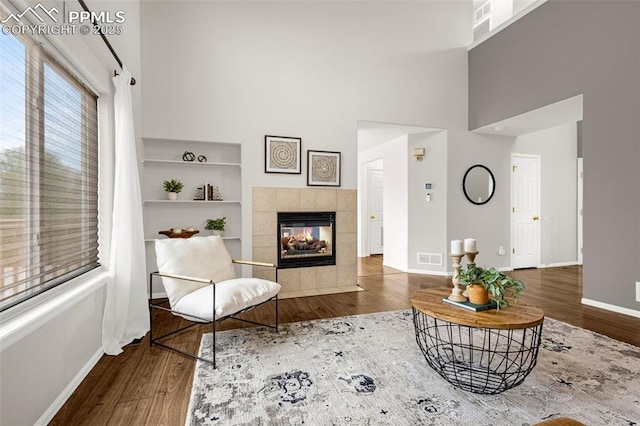 living room with baseboards, a high ceiling, and wood finished floors