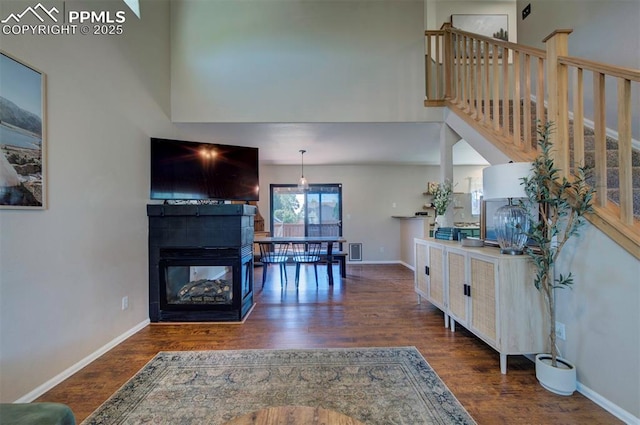 living area with baseboards and wood finished floors
