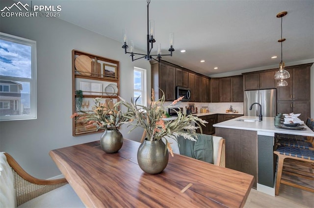 dining area with recessed lighting, baseboards, a chandelier, and light wood-style floors
