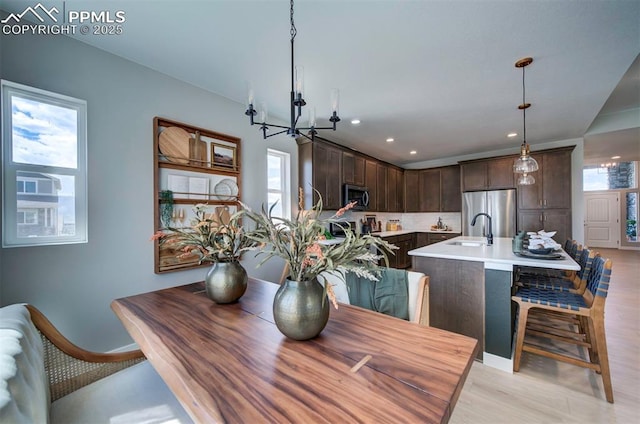 dining room featuring recessed lighting, baseboards, a chandelier, and light wood-type flooring