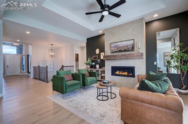 living room featuring recessed lighting, ceiling fan with notable chandelier, wood finished floors, and a fireplace