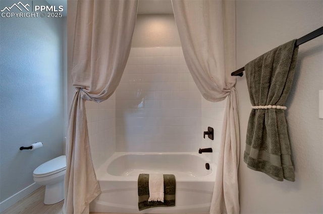 bathroom featuring shower / bath combo with shower curtain, baseboards, wood finished floors, and toilet