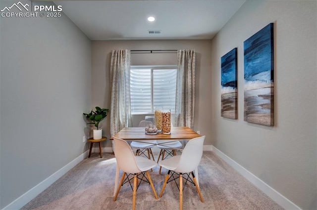 carpeted dining space with baseboards and visible vents