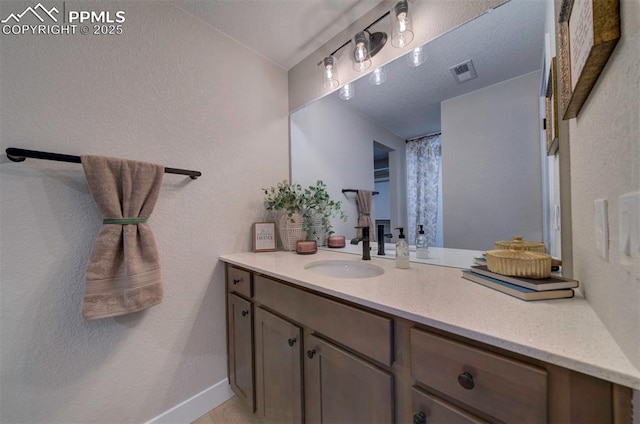 bathroom with vanity, baseboards, and visible vents