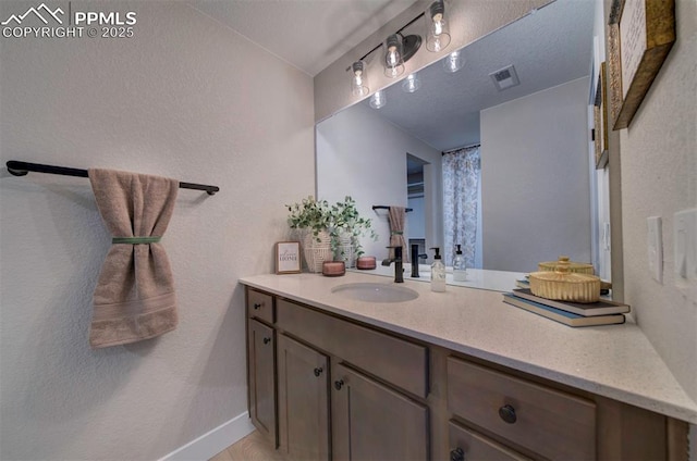 bathroom featuring baseboards, visible vents, and vanity