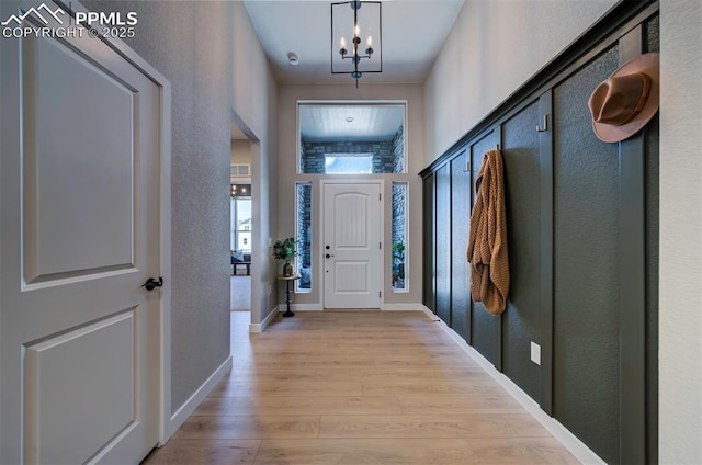interior space with baseboards, a textured wall, and light wood-type flooring