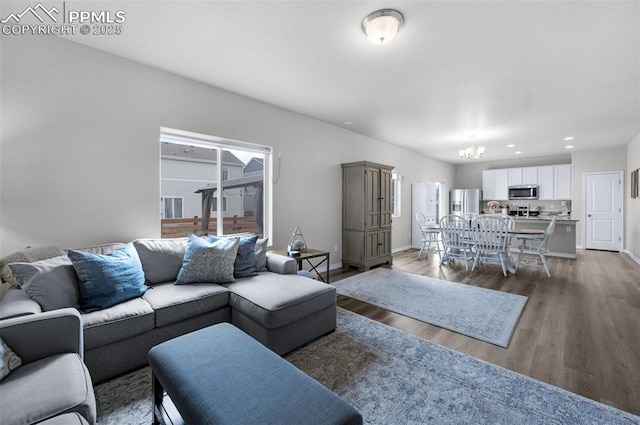 living room with baseboards, recessed lighting, wood finished floors, and a notable chandelier