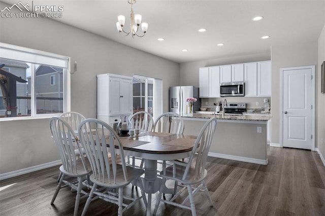 dining space featuring baseboards, recessed lighting, wood finished floors, and a chandelier