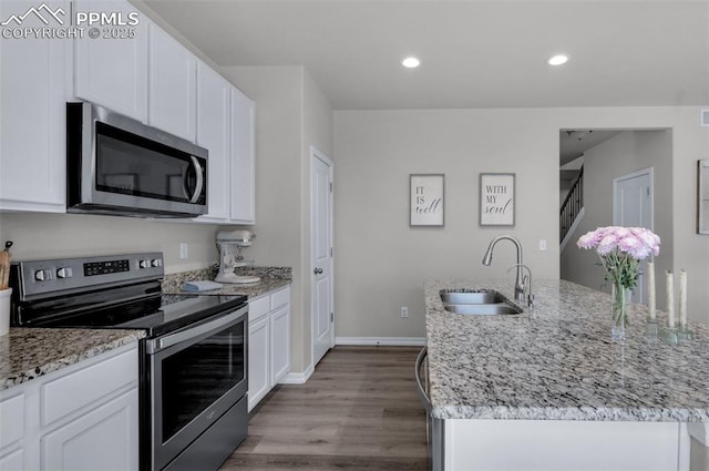 kitchen featuring a sink, white cabinetry, appliances with stainless steel finishes, and a kitchen island with sink