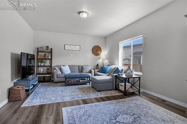 living room featuring baseboards, wood finished floors, and visible vents