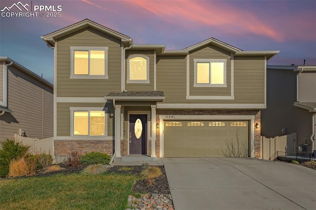 10881 Traders Pkwy, Fountain, CO 80817 - traditional home with a garage, fence, stone siding, and concrete driveway