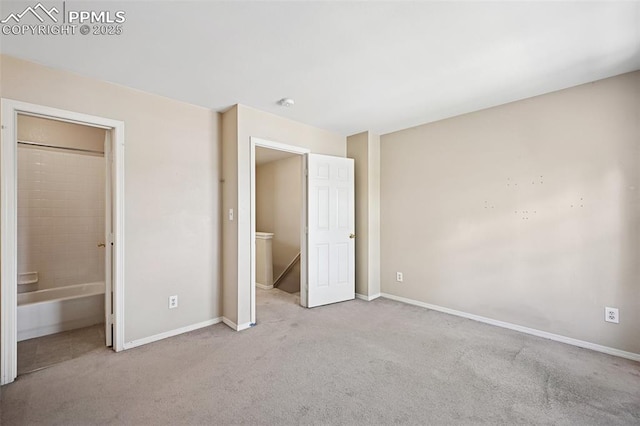 unfurnished bedroom with baseboards, carpet, and ensuite bathroom