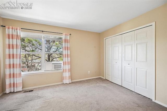 unfurnished bedroom with carpet floors, baseboards, visible vents, and a closet