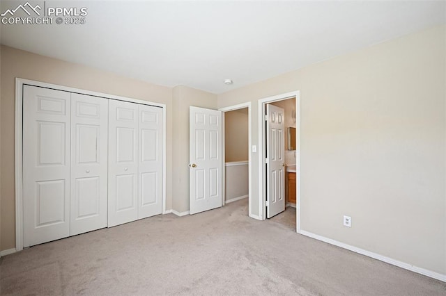 unfurnished bedroom featuring carpet floors, connected bathroom, baseboards, and a closet