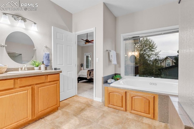 ensuite bathroom with connected bathroom, ceiling fan, tile patterned flooring, vanity, and a garden tub