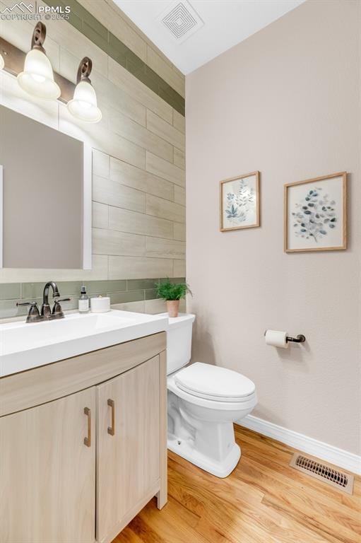bathroom with toilet, baseboards, visible vents, and vanity