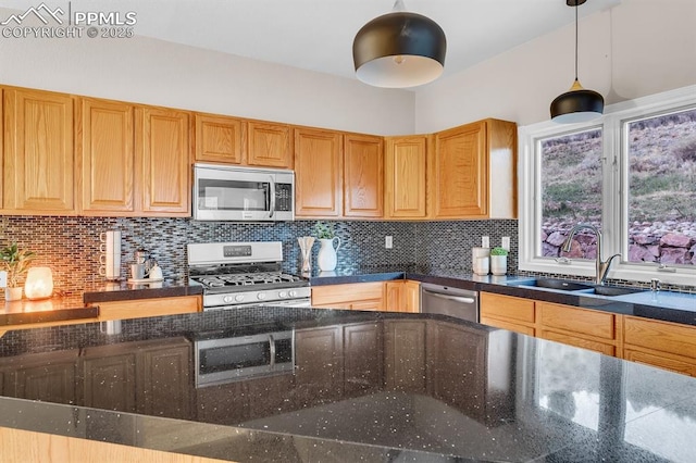 kitchen featuring a sink, dark stone counters, decorative backsplash, and stainless steel appliances