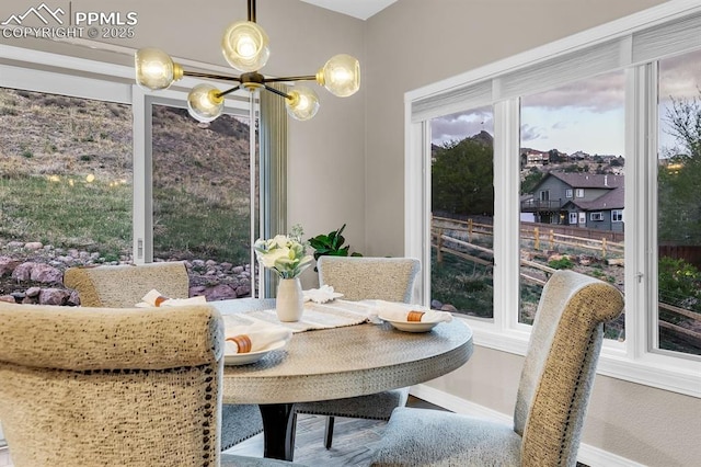 dining space with baseboards and a chandelier