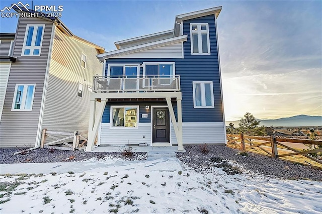 view of front of home with fence and a balcony