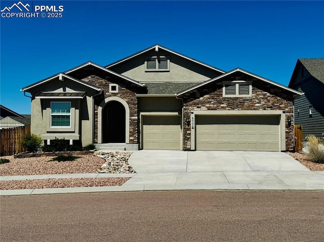craftsman inspired home featuring fence, stone siding, driveway, a garage, and stucco siding