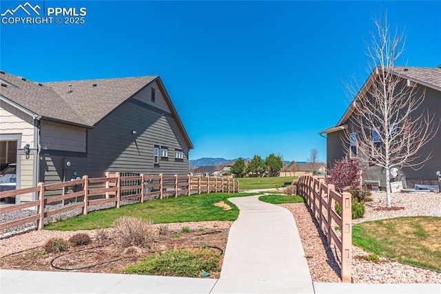 view of yard featuring a mountain view and fence