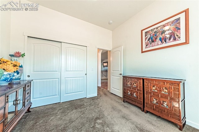 carpeted bedroom with a closet and baseboards