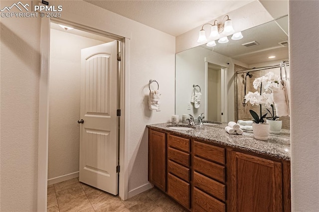 bathroom featuring baseboards, visible vents, tile patterned flooring, and vanity