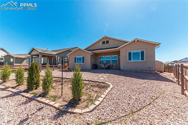 back of house with stucco siding and a fenced backyard