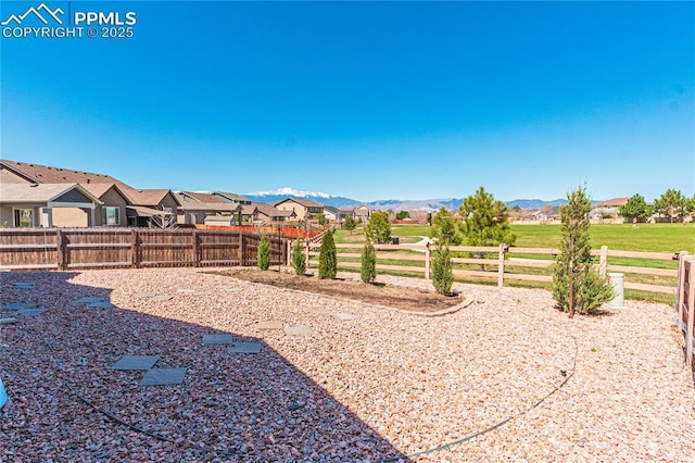 view of yard with a mountain view, a residential view, and a fenced backyard