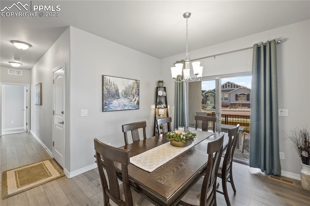 6471 Cisco Kid Way, Colorado Springs, CO 80923 - dining room with a notable chandelier, baseboards, visible vents, and hardwood / wood-style flooring