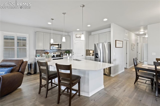 6471 Cisco Kid Way, Colorado Springs, CO 80923 - kitchen with a sink, light wood-style floors, light countertops, stainless steel appliances, and tasteful backsplash