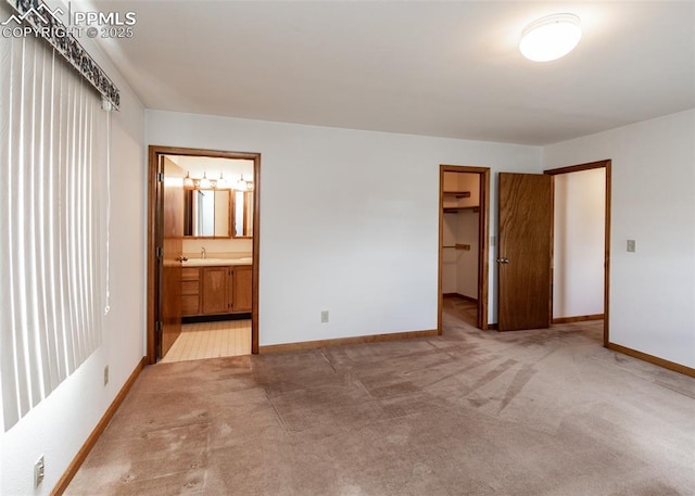 6185 Sayres Rd, Colorado Springs, CO 80927 - unfurnished bedroom featuring light carpet, baseboards, a spacious closet, a sink, and ensuite bath