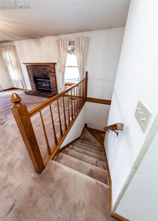 6185 Sayres Rd, Colorado Springs, CO 80927 - staircase with carpet floors and a fireplace