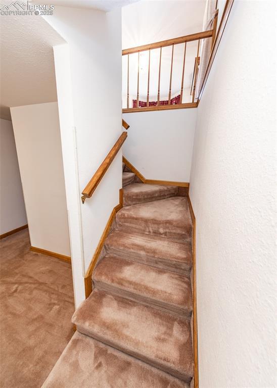 6185 Sayres Rd, Colorado Springs, CO 80927 - stairway with baseboards and carpet flooring