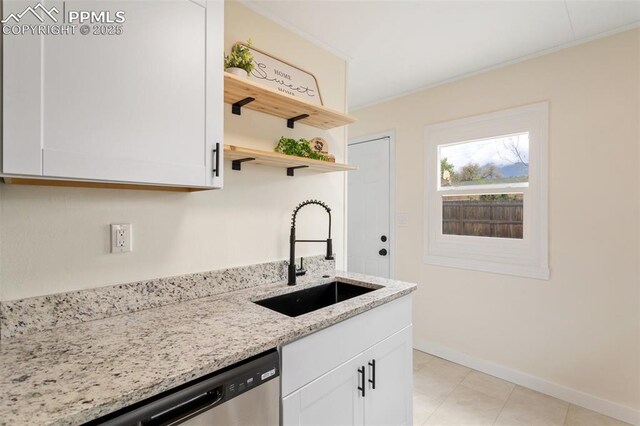 kitchen featuring white cabinetry, light stone counters, a sink, and dishwasher