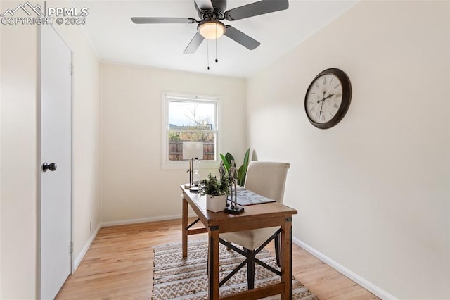 office space featuring baseboards, a ceiling fan, and light wood finished floors