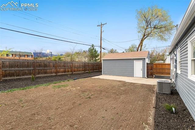 view of yard with a patio, cooling unit, an outbuilding, and a fenced backyard