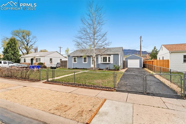 bungalow-style house with driveway, a fenced front yard, a front yard, a gate, and a detached garage