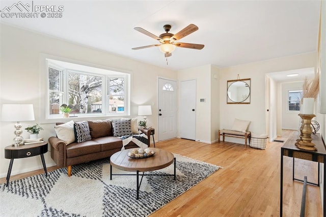 living room with baseboards, plenty of natural light, light wood finished floors, and ceiling fan