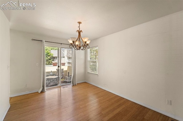 3245 Chestnut Glen Ln, Colorado Springs, CO 80918 - empty room featuring a chandelier and wood finished floors