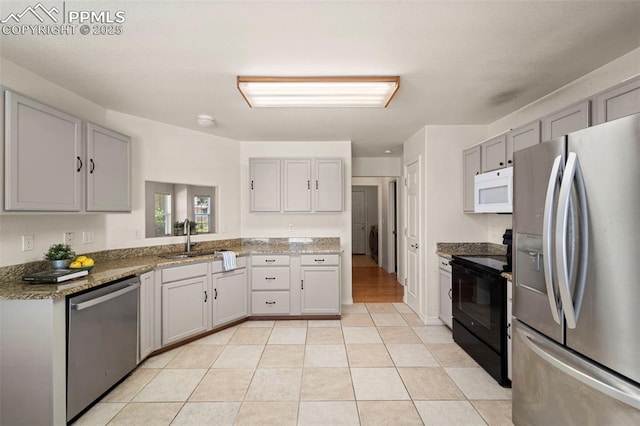 3245 Chestnut Glen Ln, Colorado Springs, CO 80918 - kitchen with appliances with stainless steel finishes, gray cabinetry, stone countertops, and light tile patterned floors
