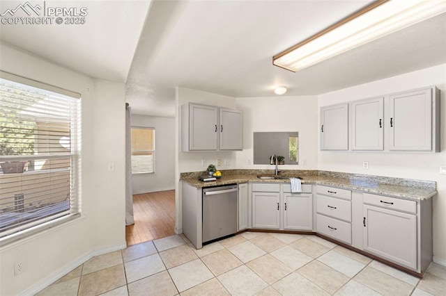 3245 Chestnut Glen Ln, Colorado Springs, CO 80918 - kitchen featuring stainless steel dishwasher, light tile patterned floors, and light stone countertops