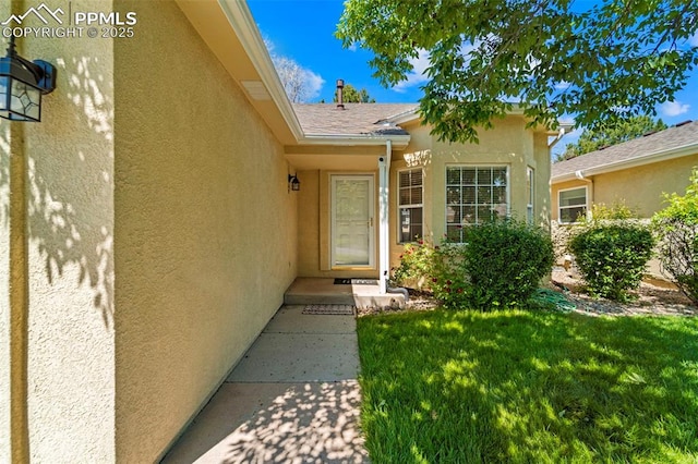 3245 Chestnut Glen Ln, Colorado Springs, CO 80918 - entrance to property with stucco siding, a lawn, and roof with shingles