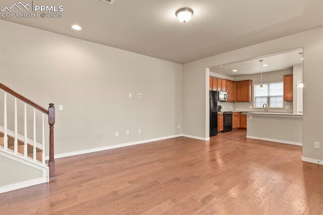 8766 Vista Azul Hts, Colorado Springs, CO 80924 - unfurnished living room with light wood finished floors, stairs, baseboards, and recessed lighting