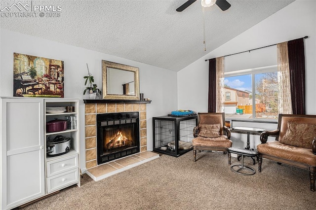 3450 Galleria Ter, Colorado Springs, CO 80916 - sitting room with lofted ceiling, a textured ceiling, a tile fireplace, a ceiling fan, and carpet